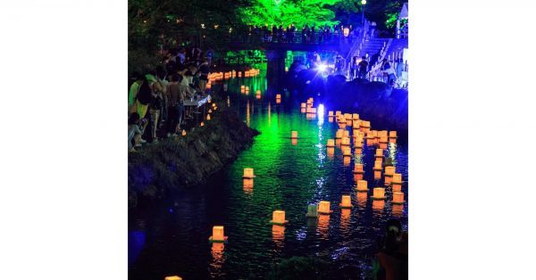 かがり火とライトアップのなか川面の浮かぶ灯ろう